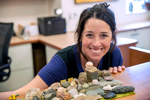 A woman with several rocks on a blanket.